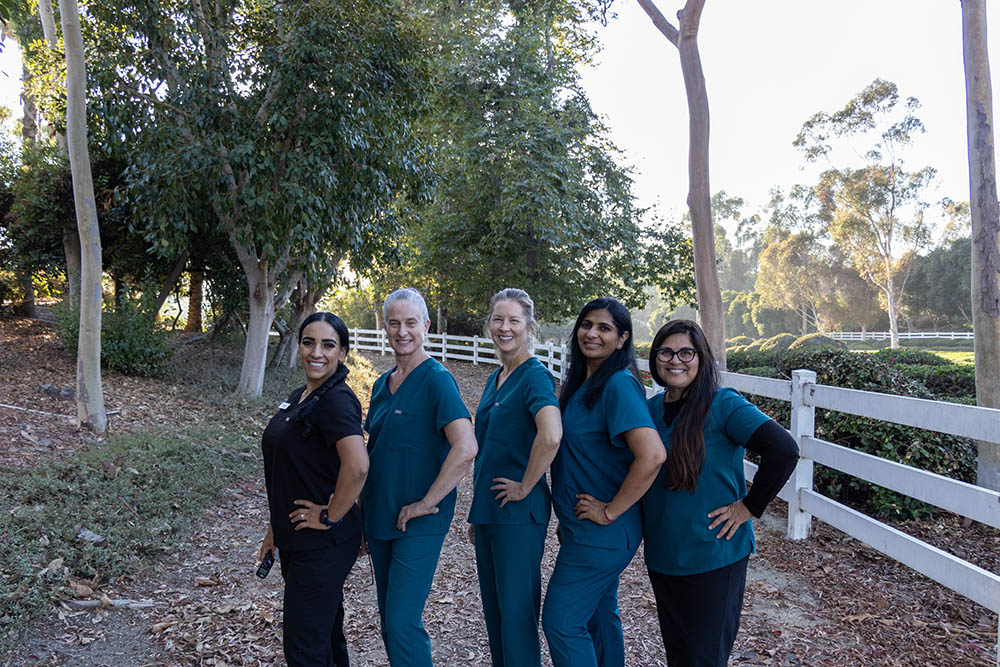 The Craft Dental team standing together outdoors beside a white fence