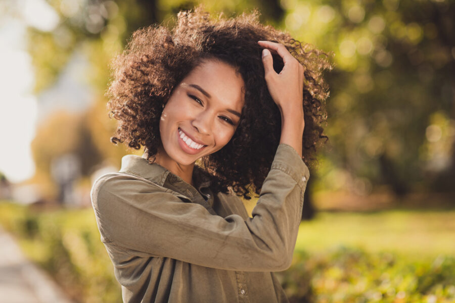 Smiling woman outdoors after successful Crown Lengthening procedure at Craft Dental, showing confidence.
