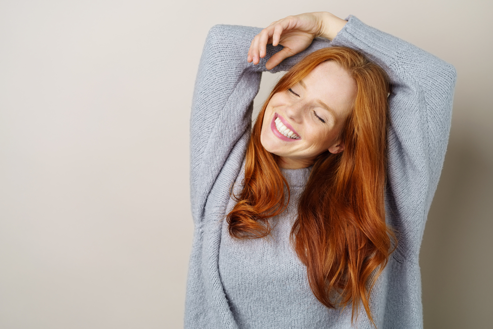 Joyful red-haired woman smiling brightly after professional Teeth Whitening treatment at Craft Dental clinic